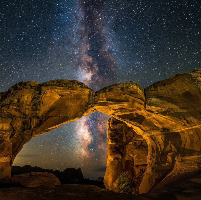 Rocks arching over a starry night sky with the Milky Way visible