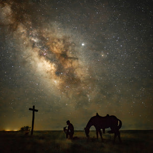 Praying cowboy statue with Milky Way background in Colorado.